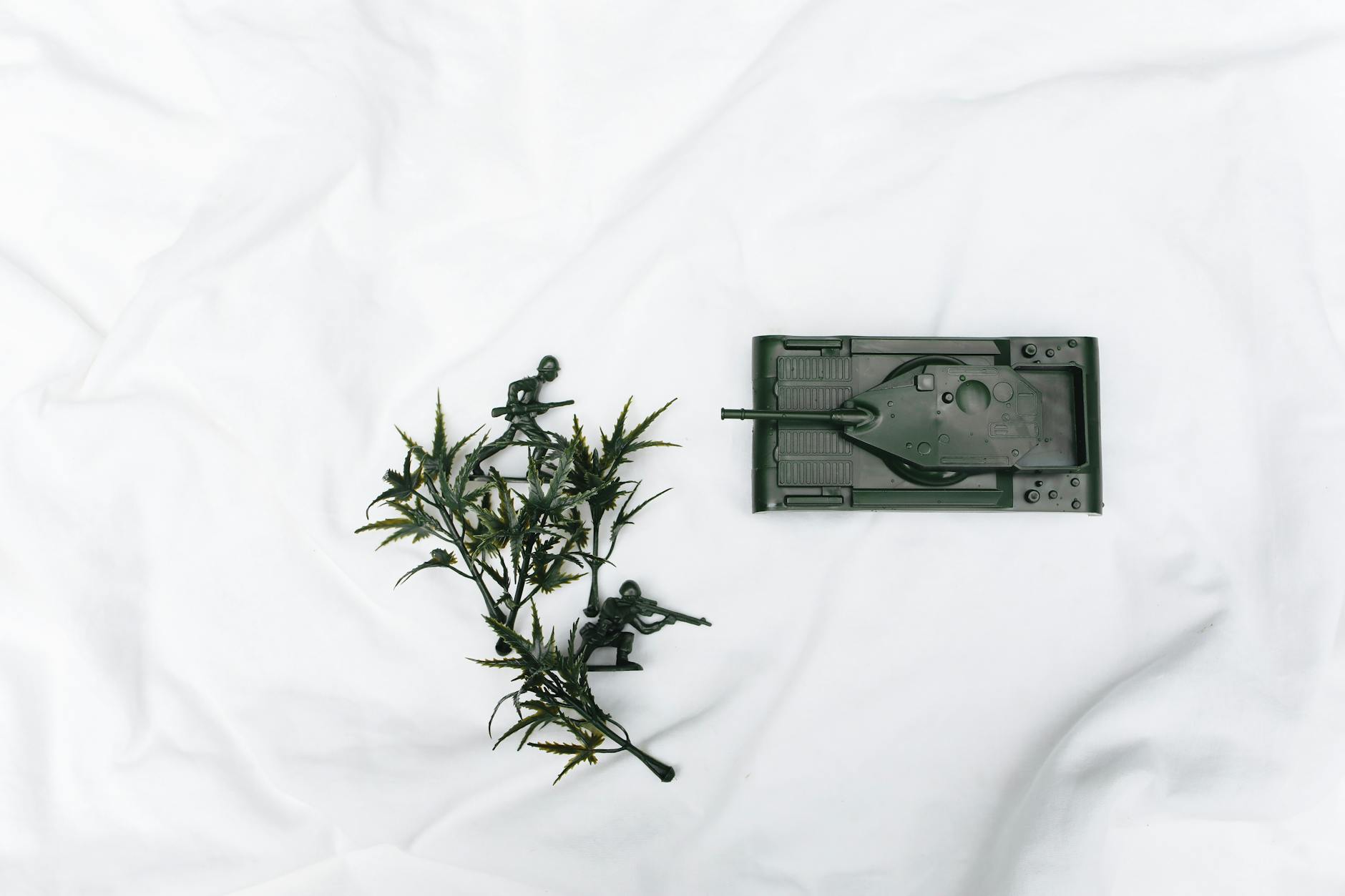 Miniaturowy czołg i żołnierze piechoty na jasnym tle