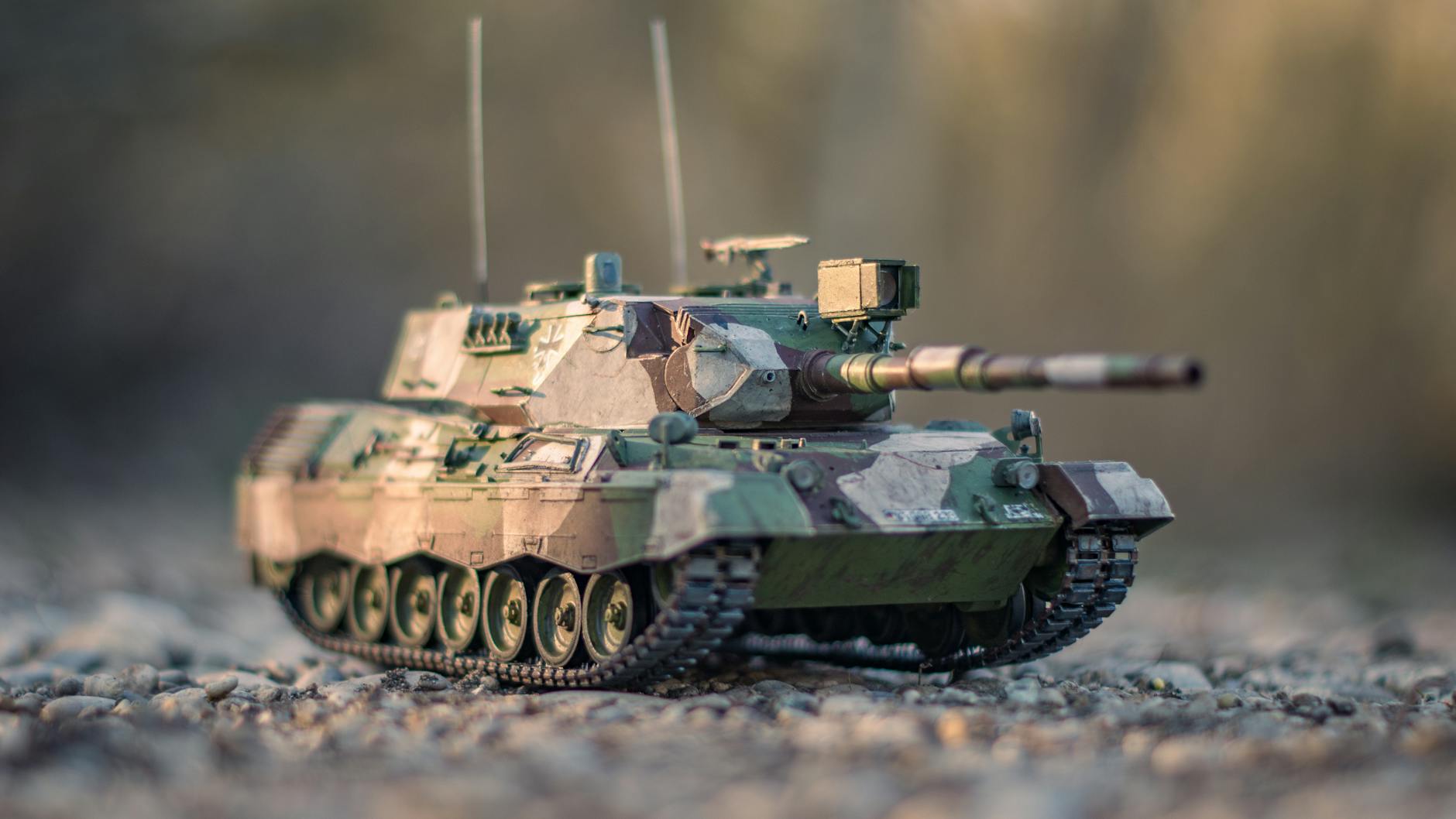 Model współczesnego czołgu w kamuflażu na żwirowej drodze