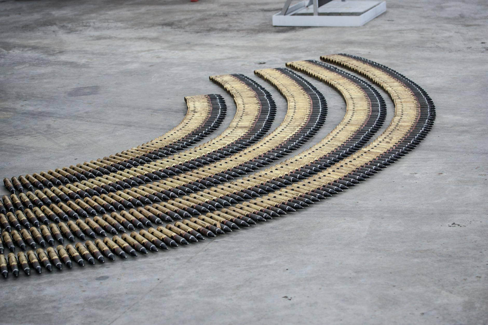 Rzędy nabojów ułożone w łuk na betonowej posadzce