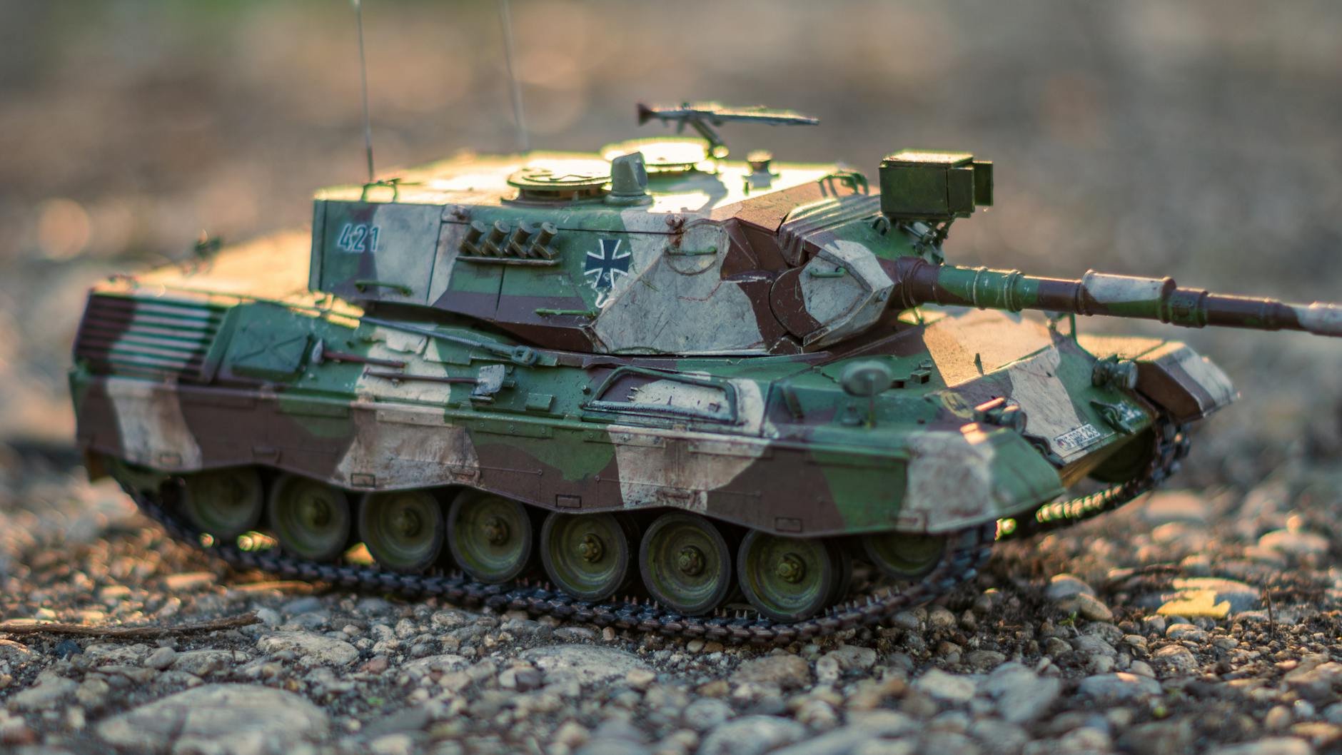 Model współczesnego czołgu w kamuflażu na kamienistym podłożu