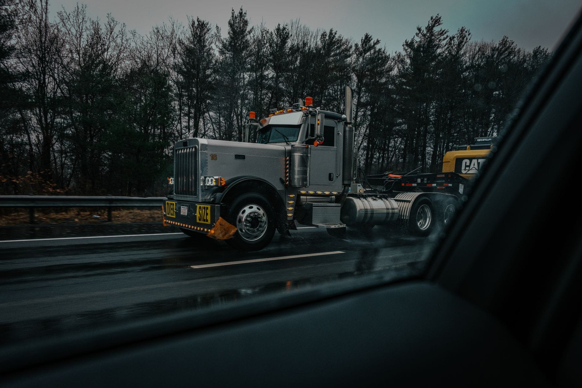 Ciężarówka z ładunkiem ponadgabarytowym na mokrej autostradzie